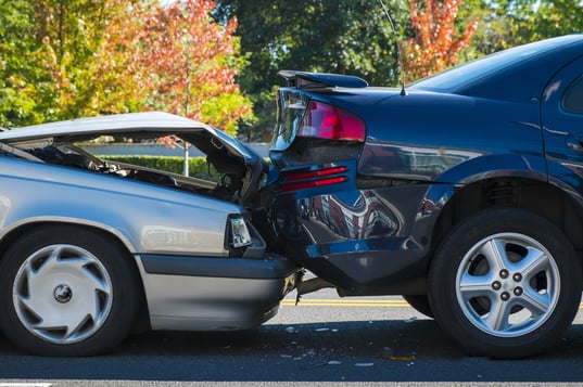 Silver car crashed into a blue car