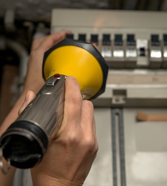 Flashlight shining into circuit breaker box