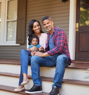 Happy african american couple on porch with baby