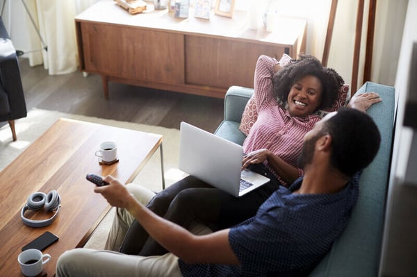 Happy couple laughing on couch together-1