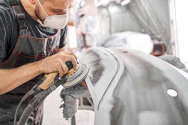 Man doing body shop work on car