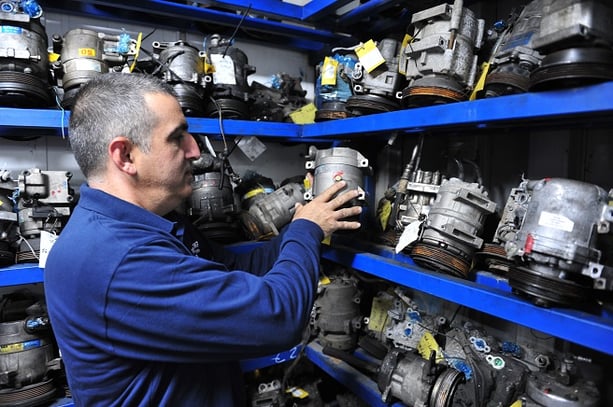 Man putting car parts on shelf