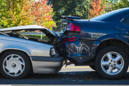 Silver car crashed into a blue car