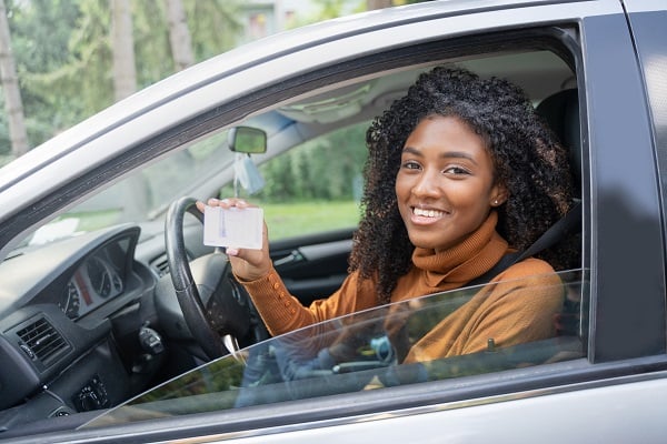 girl with new license in car