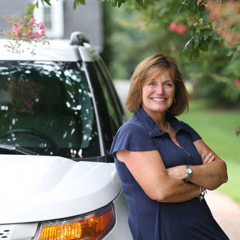 happy lady leaning on her car