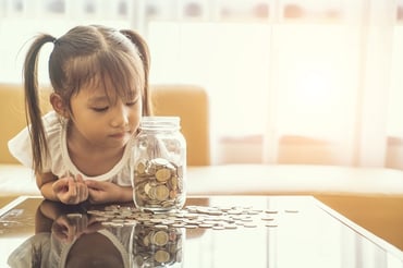 little girl with jar of money