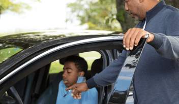 Dad showing son inside of car controls